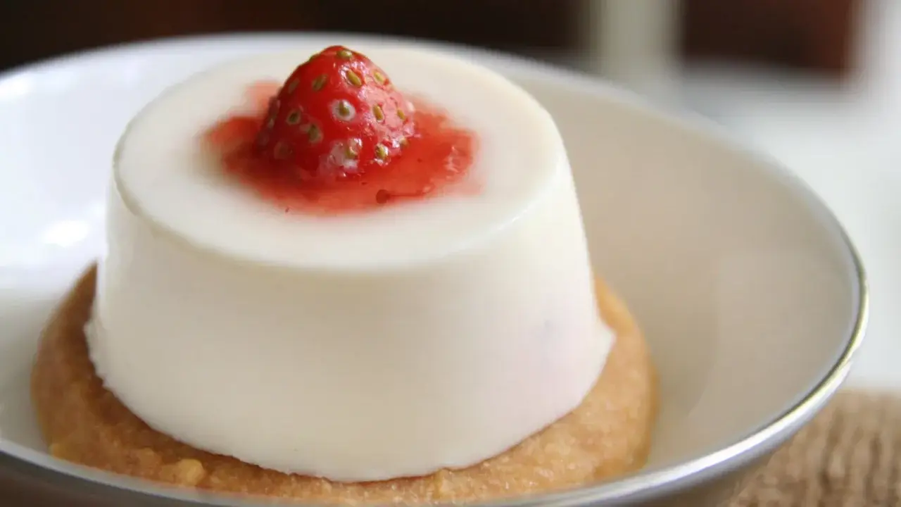 Panna cotta à la fraise sur un biscuit. Si elle est trop liquide, pas de panique, voici comment rattraper une panna cotta trop liquide.