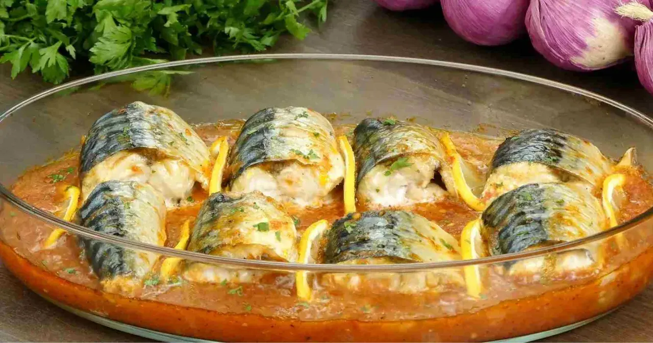 Délicieux maquereau au four, baignant dans une sauce tomate savoureuse, garni de rondelles de citron et de persil frais.