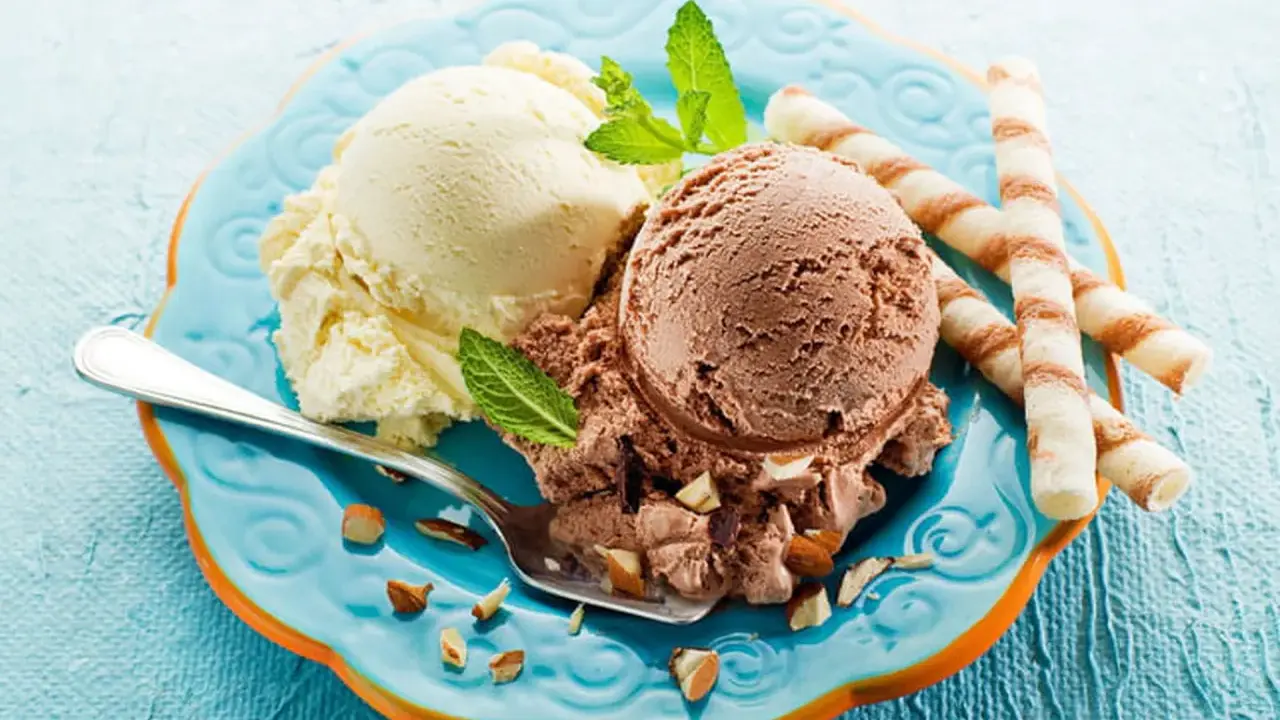 Glace italienne maison sans machine : deux boules vanille et chocolat, garnies d'amandes et de menthe, avec des gaufrettes.