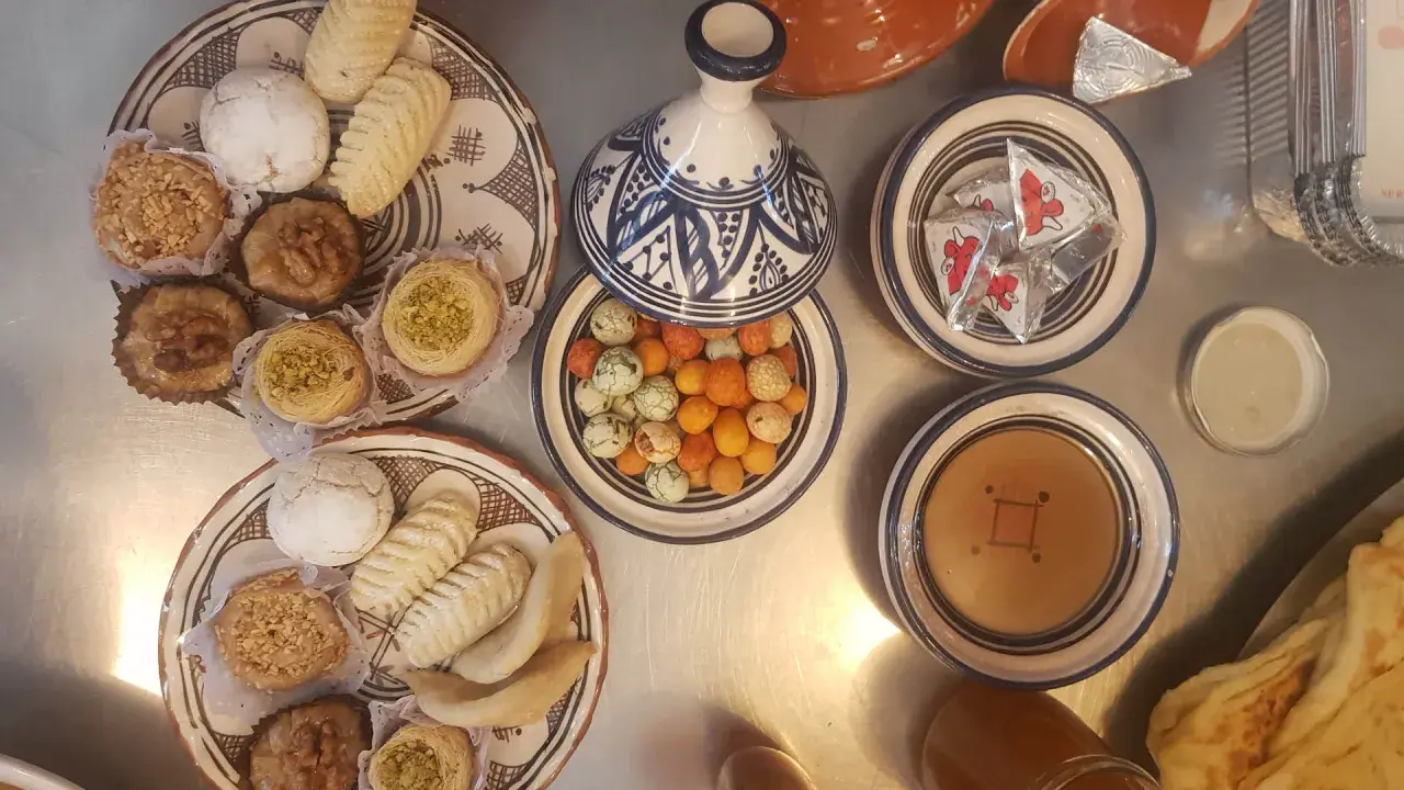 Assortiment de pâtisseries orientales, parfait pour une recette marocaine. Des biscuits, des nids de pistaches, des fruits secs et des bonbons colorés.