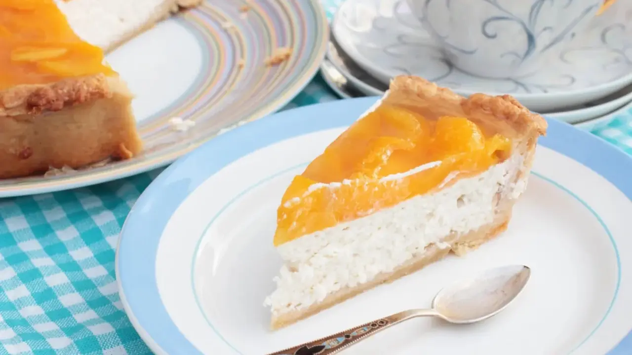 Tranche de cheesecake aux pêches, une gourmandise légère. L'agar agar, son utilisation, assure une texture parfaite.