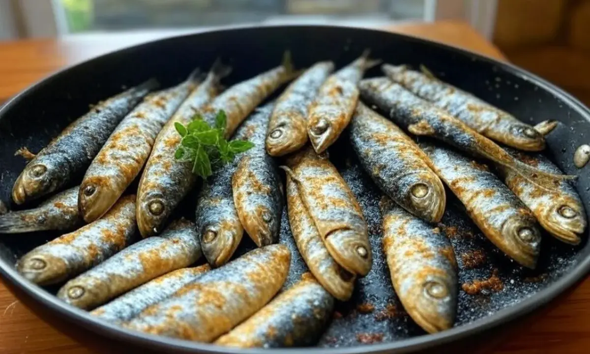 Sardines dorées et assaisonnées dans une poêle, prêtes pour une délicieuse recette sardine. Une touche de persil frais pour la garniture.