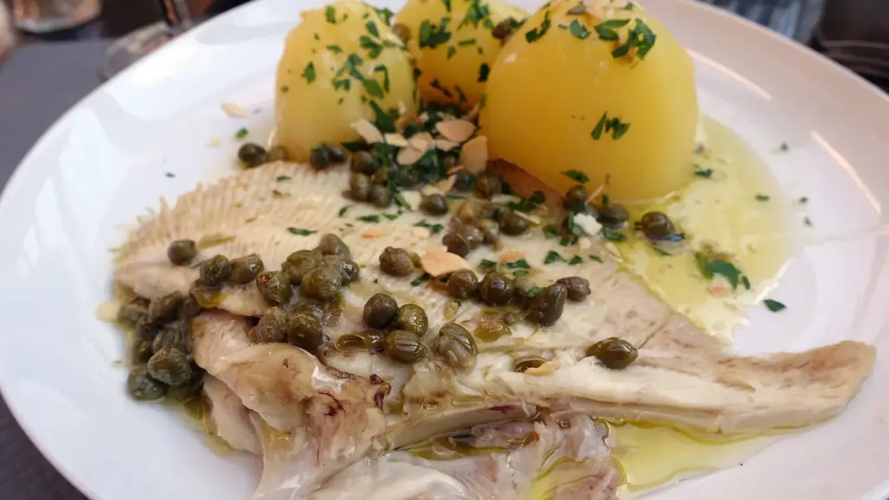 Une aile de raie poêlée, nappée de sauce aux câpres et amandes, accompagnée de pommes de terre vapeur. Une recette simple et savoureuse.