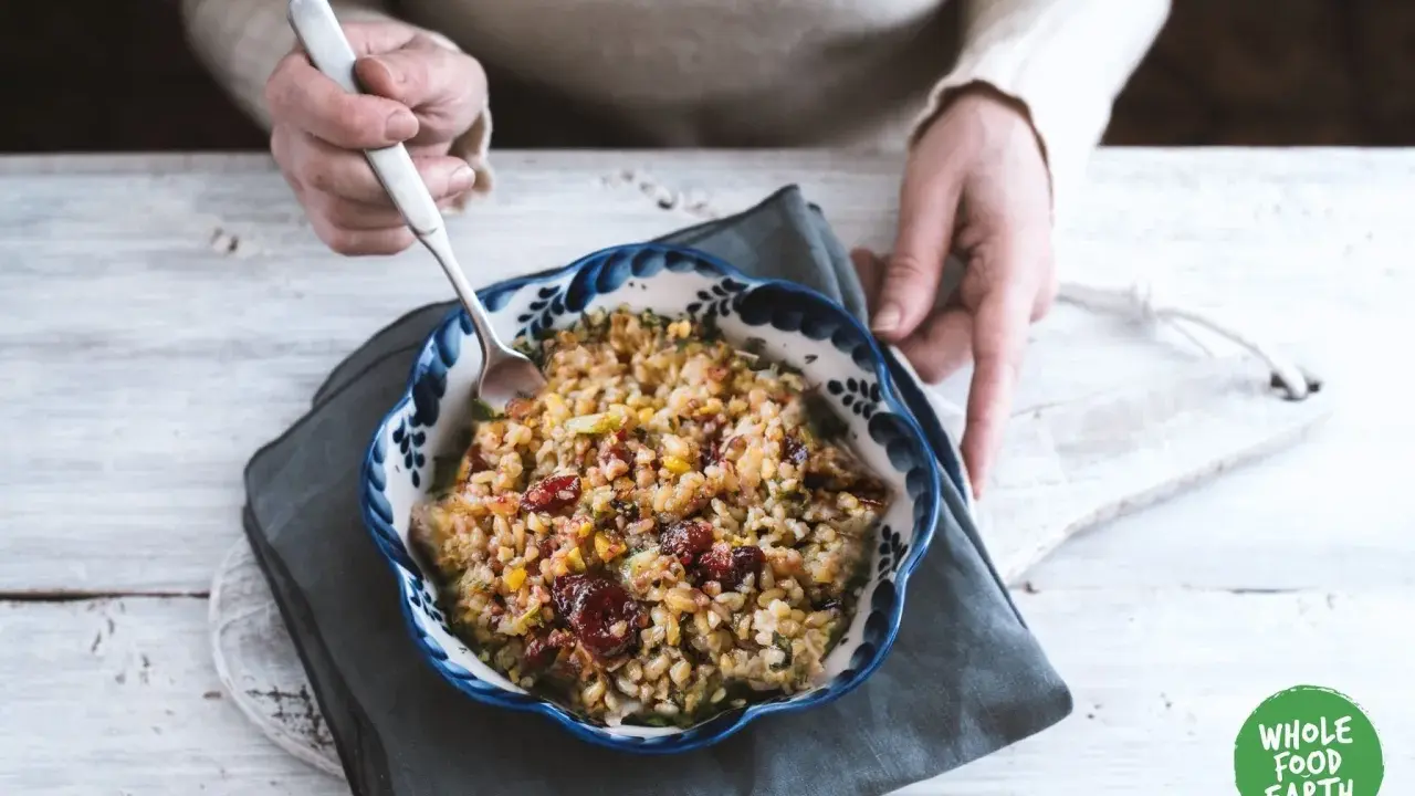 Un bol de freekeh recette, garni de canneberges et de légumes, prêt à être dégusté.
