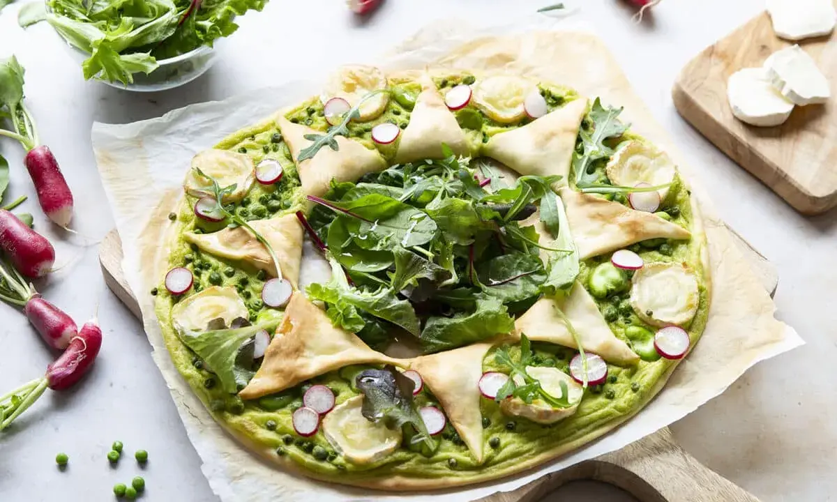 Tarte printanière aux fèves, petits pois, radis et fromage de chèvre. Une idée de recettes originales pour un repas léger et savoureux.