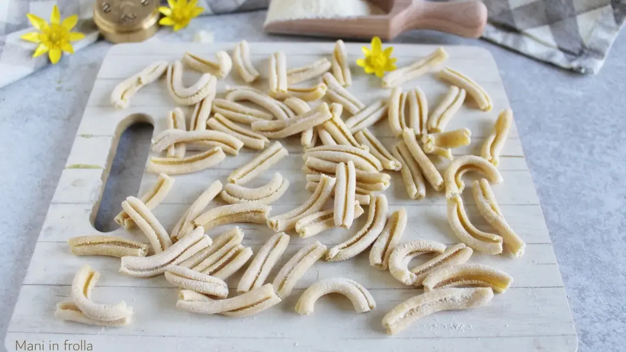 Des pâtes fraîches, prêtes à être cuites. Un aperçu de comment faire des pâtes maison, avec un rouleau à pâtes et de la farine.