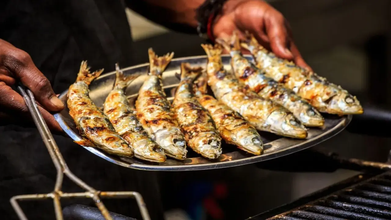 Une assiette de sardines grillées, dorées et savoureuses, prêtes à être dégustées.