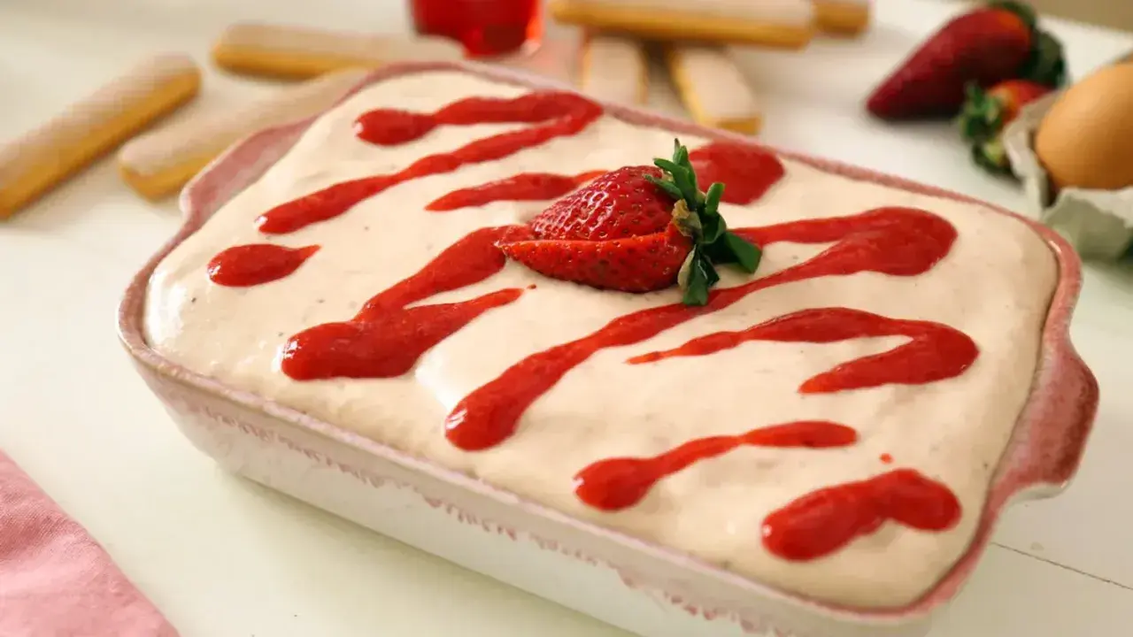 Tiramisu fraise crémeux, avec 500g de mascarpone, garni de coulis de fraises et d'une fraise fraîche.