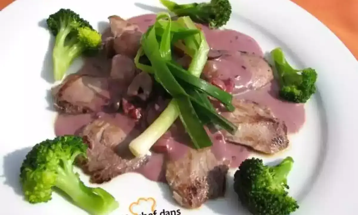 Tranches de viande en sauce rosée, accompagnées de brocolis et d'oignons verts. Une bonite recette à essayer !
