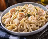 Délicieuses pâtes aux crevettes, une recette italienne crémeuse et savoureuse, garnie de persil frais.