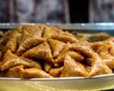 Un plateau rempli de délicieux triangles dorés, un dessert marocain traditionnel, parsemé de graines de sésame.