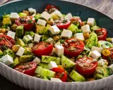 Salade colorée avec tomates, avocat, concombre, pois chiches et cubes de feta. Une recette fraîche et légère, parfaite pour un repas d'été.