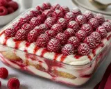 Un délicieux tiramisu framboise, garni de fruits rouges frais et saupoudré de sucre glace. Un dessert fruité et gourmand.