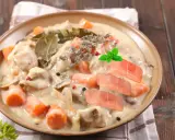 Délicieuse blanquette de poisson crémeuse avec carottes, champignons, herbes et garnie de tranches de saumon frais.