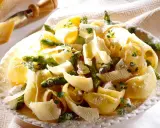 Pâtes aux asperges, garnies de copeaux de parmesan et de persil frais. Un plat printanier savoureux.