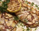 Délicieuse truite aux amandes au four, garnie d'une tranche de citron grillé et de persil frais.