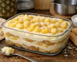 Un délicieux tiramisu ananas, superposant biscuits, crème onctueuse et morceaux d'ananas frais, saupoudré de noix de coco râpée.