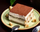 Un tiramisu onctueux, saupoudré de cacao, servi avec des morceaux de fruits. Une idée pour par quoi remplacer le café dans le tiramisu ?