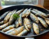 Sardines dorées et assaisonnées dans une poêle, prêtes pour une délicieuse recette sardine. Une touche de persil frais pour la garniture.