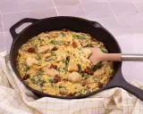 Un plat réconfortant de one pot orzo avec poulet, épinards et tomates séchées, servi dans une poêle en fonte.