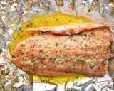 Filet de truite cuit en papillote, assaisonné d'ail et d'herbes, baignant dans un jus doré. Une recette simple et savoureuse.