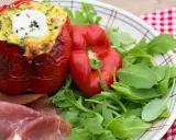 Poivrons farcis à l'italienne, garnis d'une préparation savoureuse et surmontés d'une touche de crème fraîche. Servi avec roquette et fines tranches de jambon.
