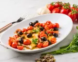Filet de merlan servi avec tomates cerises, olives noires et câpres. Une assiette colorée et savoureuse.