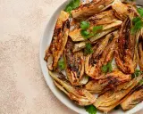 Fennouil rôti, coupé en quartiers, assaisonné et garni de coriandre fraîche. Une belle façon de cuisiner le fenouil pour un plat savoureux.