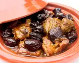 Un plat de tajine aux pruneaux, avec des morceaux de viande mijotés dans une sauce onctueuse et des pruneaux moelleux.