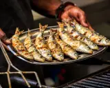Une assiette de sardines grillées, dorées et savoureuses, prêtes à être dégustées.