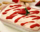 Tiramisu fraise crémeux, avec 500g de mascarpone, garni de coulis de fraises et d'une fraise fraîche.