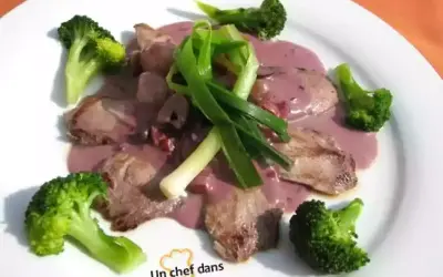 Tranches de viande en sauce rosée, accompagnées de brocolis et d'oignons verts. Une bonite recette à essayer !