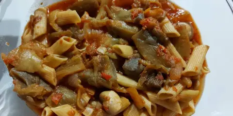 Pâtes penne avec une sauce riche aux légumes d'aubergine et tomate, un délice pour une recette pâte aux légumes italienne.
