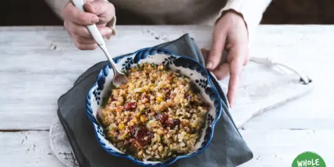 Un bol de freekeh recette, garni de canneberges et de légumes, prêt à être dégusté.