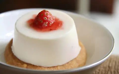 Panna cotta à la fraise sur un biscuit. Si elle est trop liquide, pas de panique, voici comment rattraper une panna cotta trop liquide.