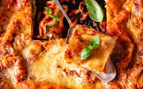 Une part de lasagne généreuse, dorée et gratinée, garnie de basilic frais. Le choix de quelle viande pour lasagne est essentiel pour ce plat réconfortant.