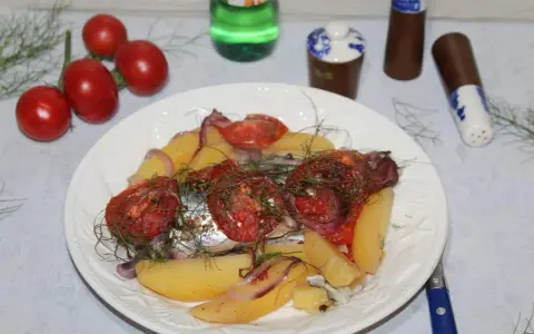 Maquereau au vin blanc, pommes de terre, tomates et oignons sur une assiette blanche.