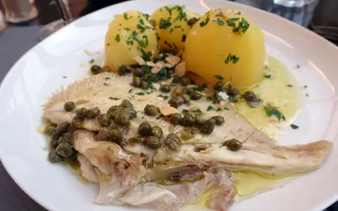 Une aile de raie poêlée, nappée de sauce aux câpres et amandes, accompagnée de pommes de terre vapeur. Une recette simple et savoureuse.