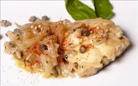Un plat de lotte aux oignons, câpres et épices, parfait pour une recette lotte facile et rapide.