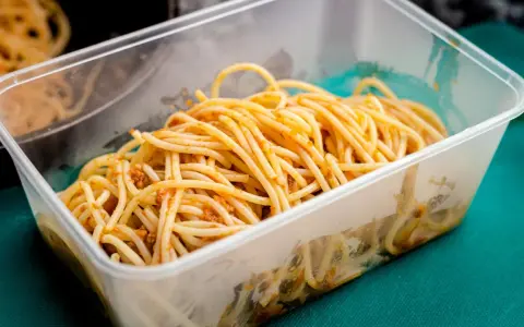 Boîte transparente remplie de spaghettis à la sauce bolognaise, idéale pour la conservation des pâtes cuites.