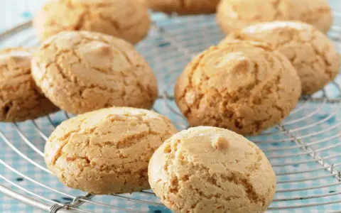 Amaretti dorés et craquelés sur une grille, prêts à être dégustés. Une recette facile pour un plaisir gourmand.
