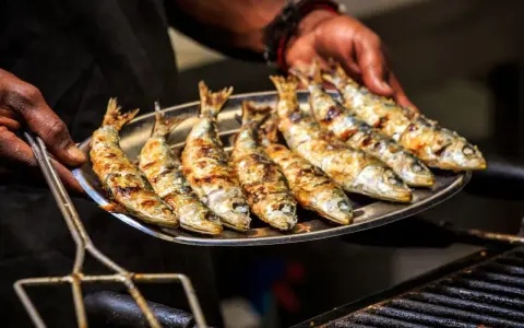 Une assiette de sardines grillées, dorées et savoureuses, prêtes à être dégustées.