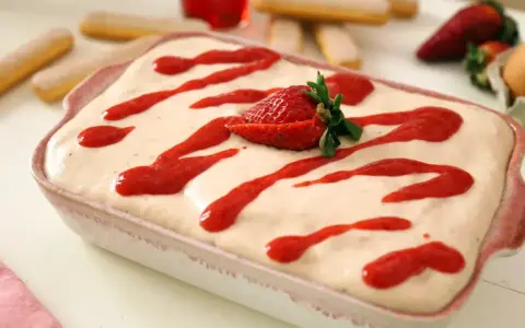 Tiramisu fraise crémeux, avec 500g de mascarpone, garni de coulis de fraises et d'une fraise fraîche.