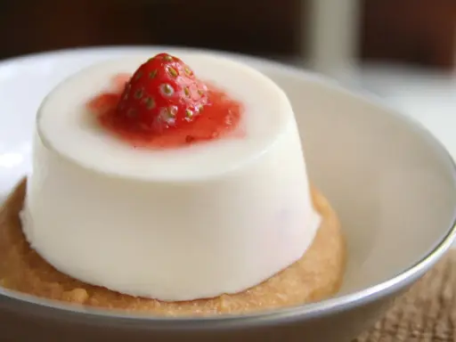 Panna cotta à la fraise sur un biscuit. Si elle est trop liquide, pas de panique, voici comment rattraper une panna cotta trop liquide.