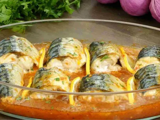 Délicieux maquereau au four, baignant dans une sauce tomate savoureuse, garni de rondelles de citron et de persil frais.