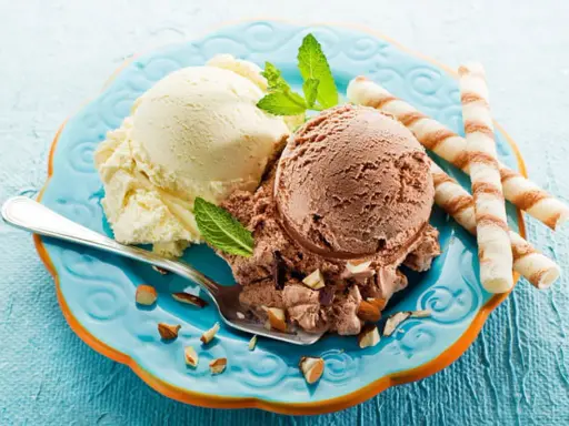 Glace italienne maison sans machine : deux boules vanille et chocolat, garnies d'amandes et de menthe, avec des gaufrettes.