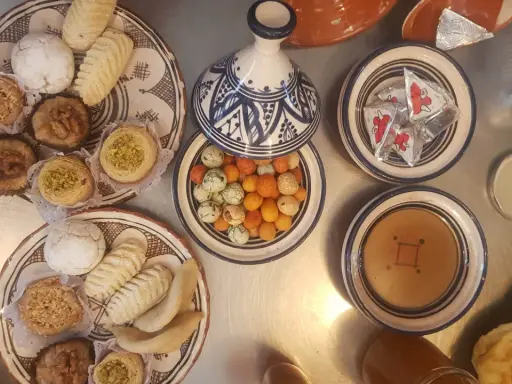 Assortiment de pâtisseries orientales, parfait pour une recette marocaine. Des biscuits, des nids de pistaches, des fruits secs et des bonbons colorés.