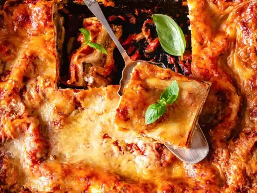 Une part de lasagne généreuse, dorée et gratinée, garnie de basilic frais. Le choix de quelle viande pour lasagne est essentiel pour ce plat réconfortant.