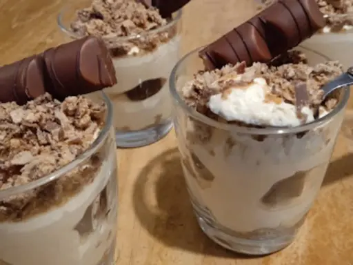 Délicieux tiramisu kinder bueno en verrines, garni de miettes croustillantes et d'un morceau de chocolat. Un vrai régal !