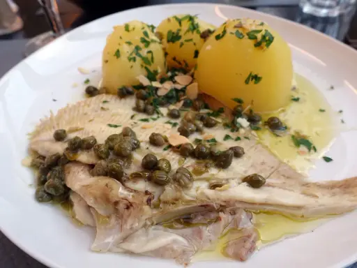 Une aile de raie poêlée, nappée de sauce aux câpres et amandes, accompagnée de pommes de terre vapeur. Une recette simple et savoureuse.
